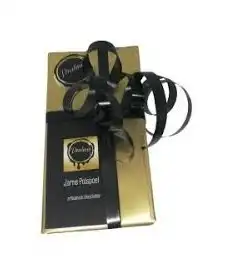 De zwart-gouden geschenkdoos van Pralinio met zwart lint en het etiket Jarne Polspoel, artisanale chocolatier